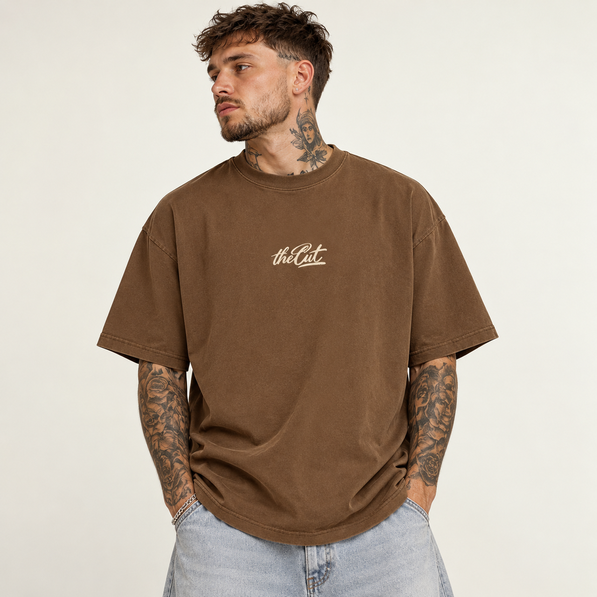 Model wearing theCut Club du Cut tee in washed brown, front view, with a small cream script logo at the left chest.