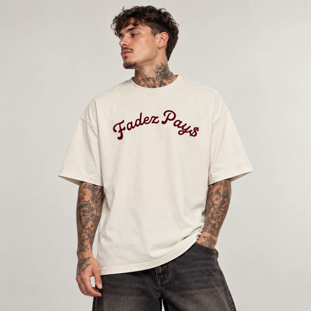 Model wearing theCut FP tee in beige, front view, with a burgundy script logo across the chest.