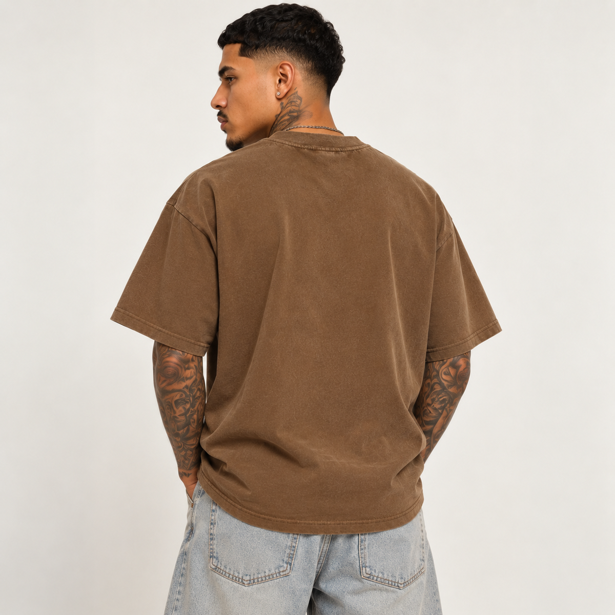 Model seen from behind wearing theCut FP tee in washed brown, showing the plain back and boxy shoulder fit.
