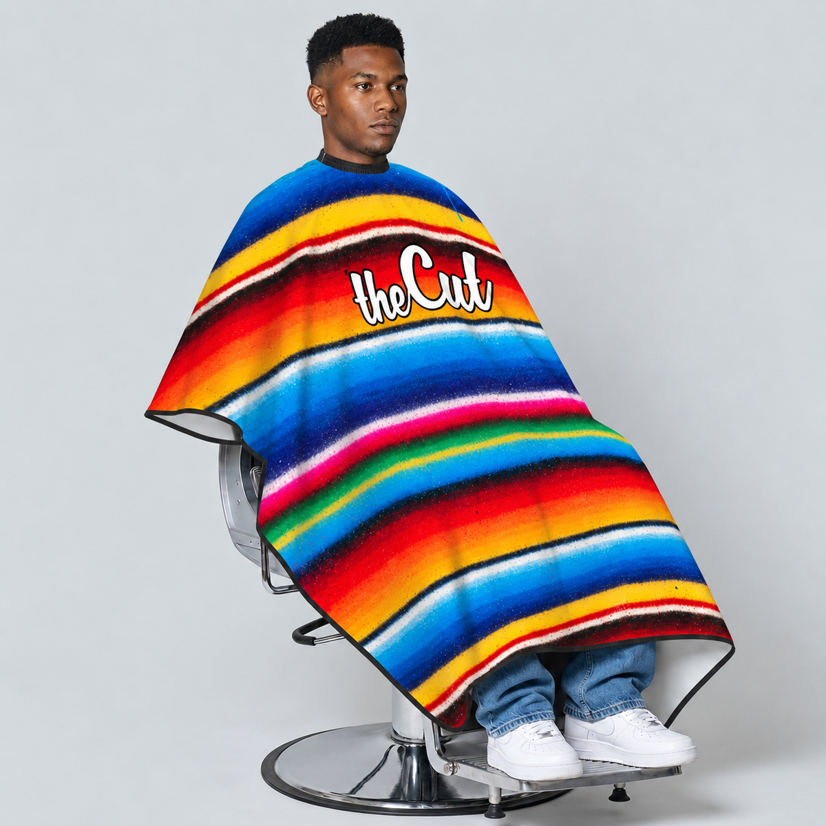 theCut Graffiti Serape Cape — seated model view on grey background