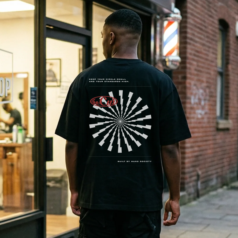 Model wearing theCut Lightning Burst tee in black outside a lit storefront.