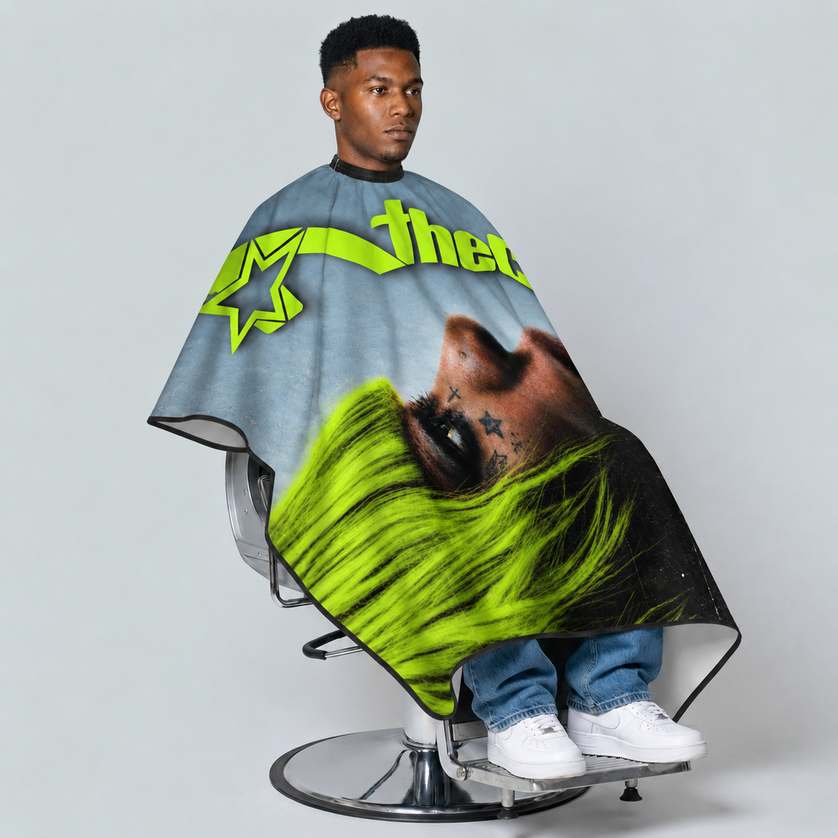theCut Neon Muse Cape — seated model view on grey background