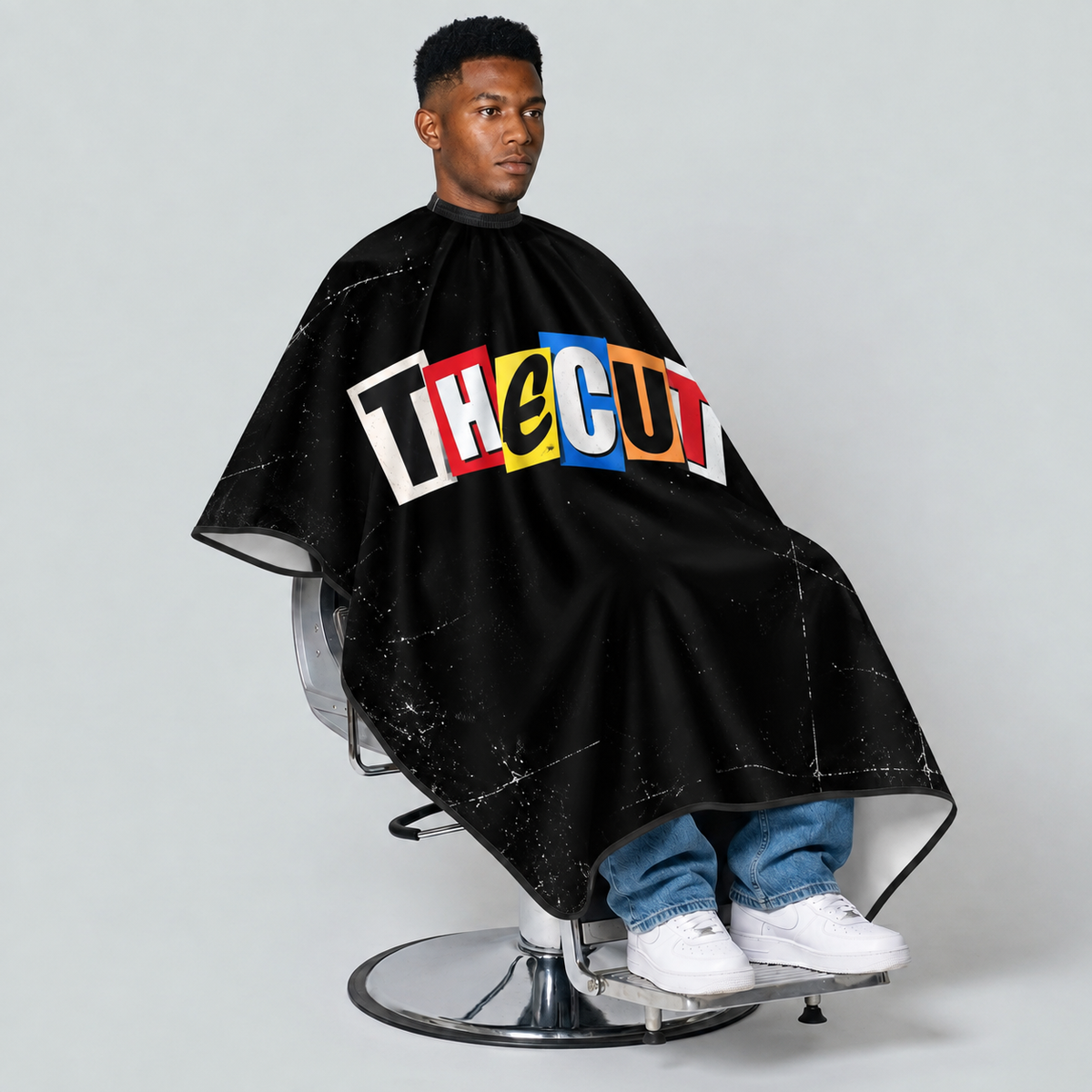 theCut Ransom Note Cape — seated view on grey background