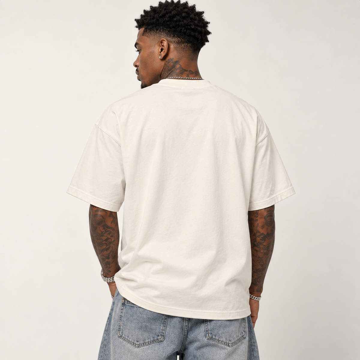 Model seen from behind wearing theCut tee in beige, showing the plain back and boxy shoulder fit.