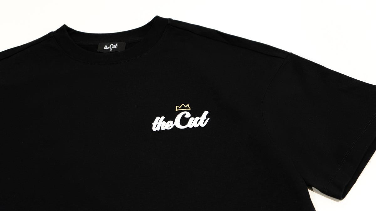 Close detail of theCut Anywhere tee in black, showing theCut script logo.
