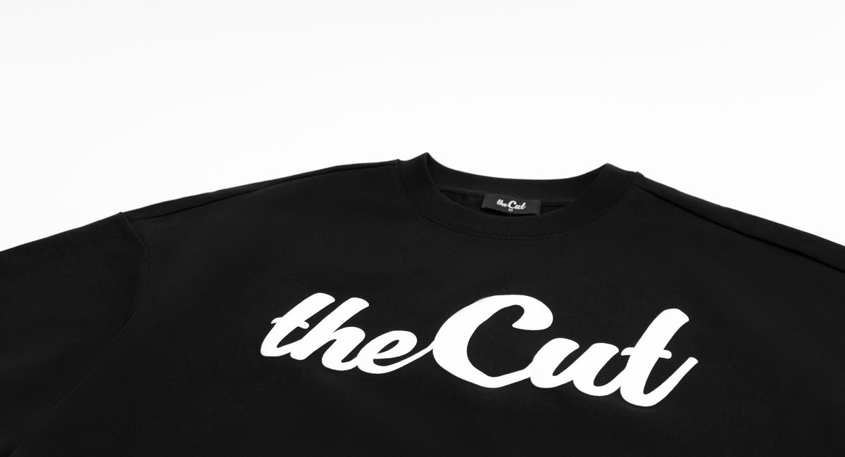 Close detail of theCut Puffed Logo tee in black, showing the raised puff print texture.